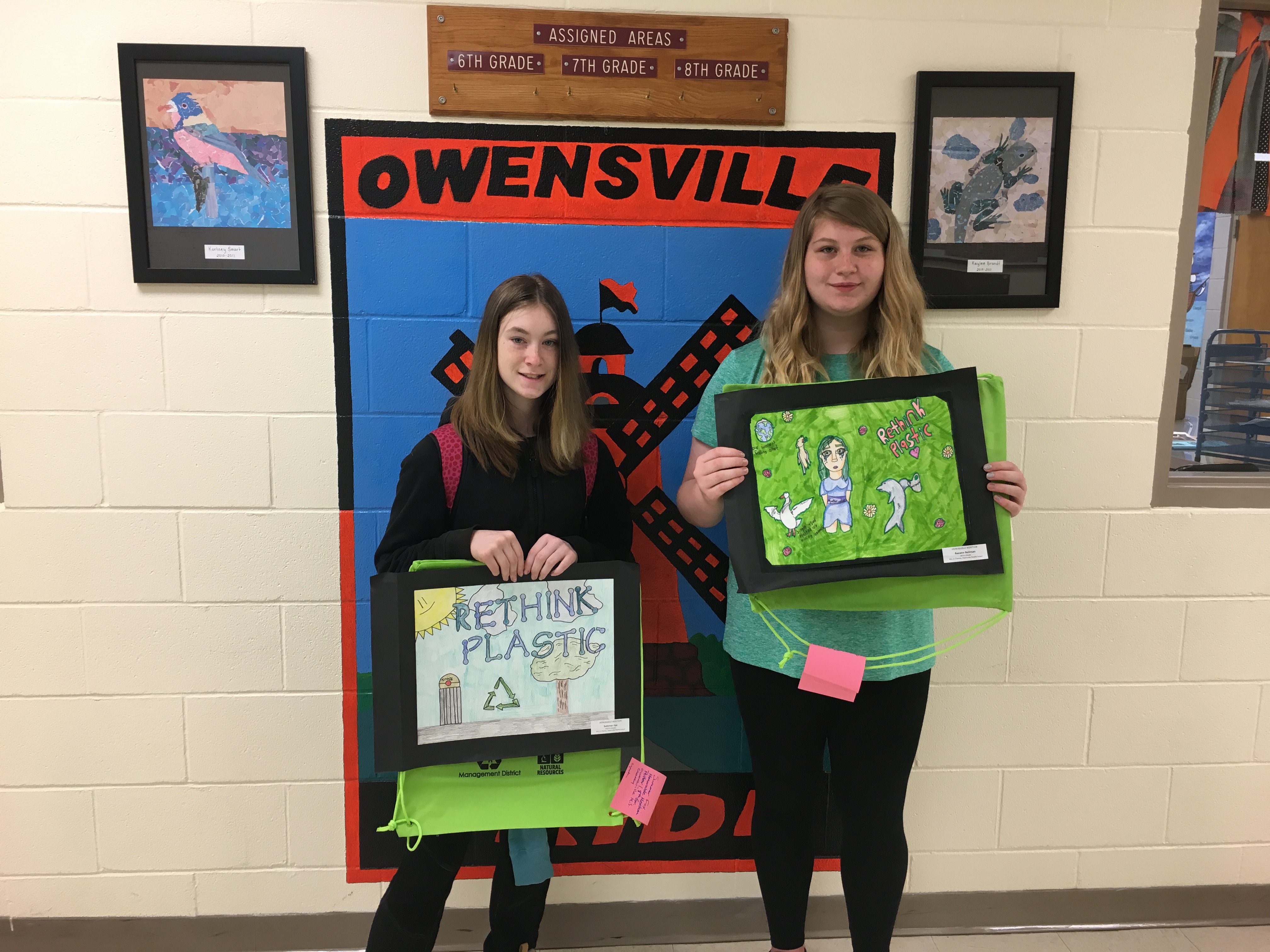 two female students showing posters - Ozark Rivers Solid Waste Management District