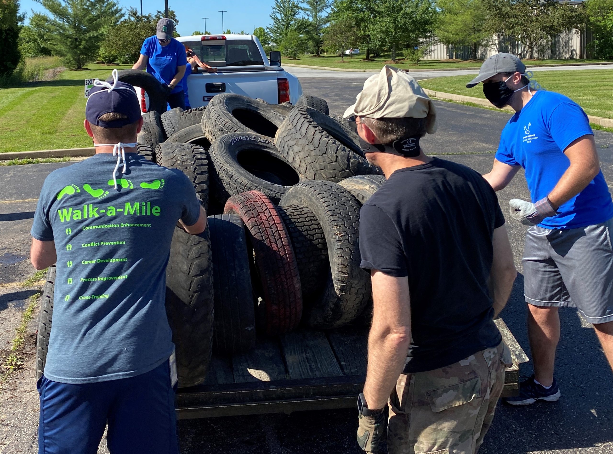Volunteers unload trailer of tires