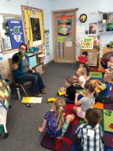 Educator shares turtle puppet with preschoolers.